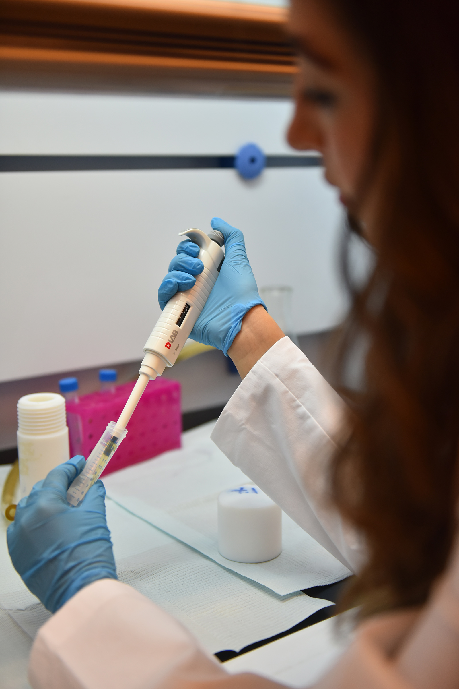 Girl wearing a lab coat performing a test 