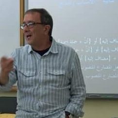 a man wearing glasses teaching in a class