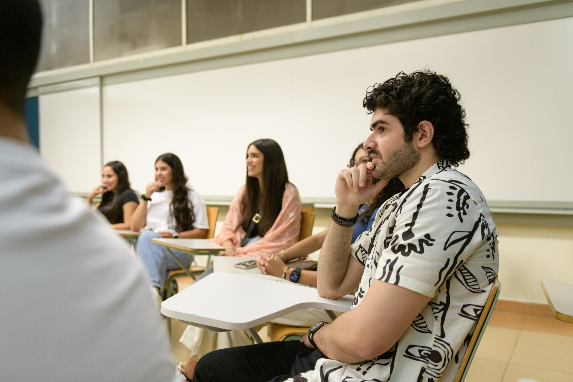 a student sitting in classroom with his classmates