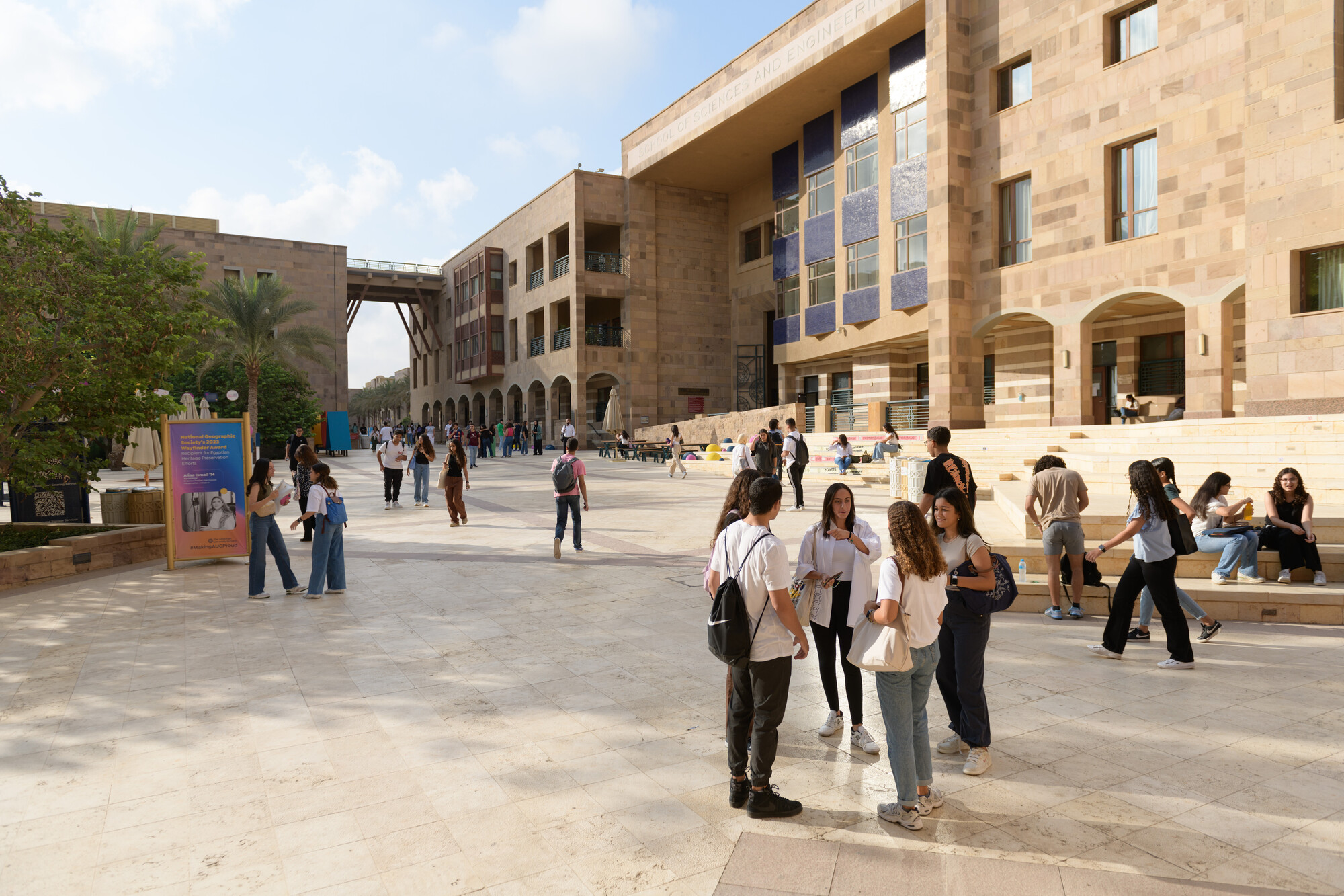 a group of students standing together chatting on campus