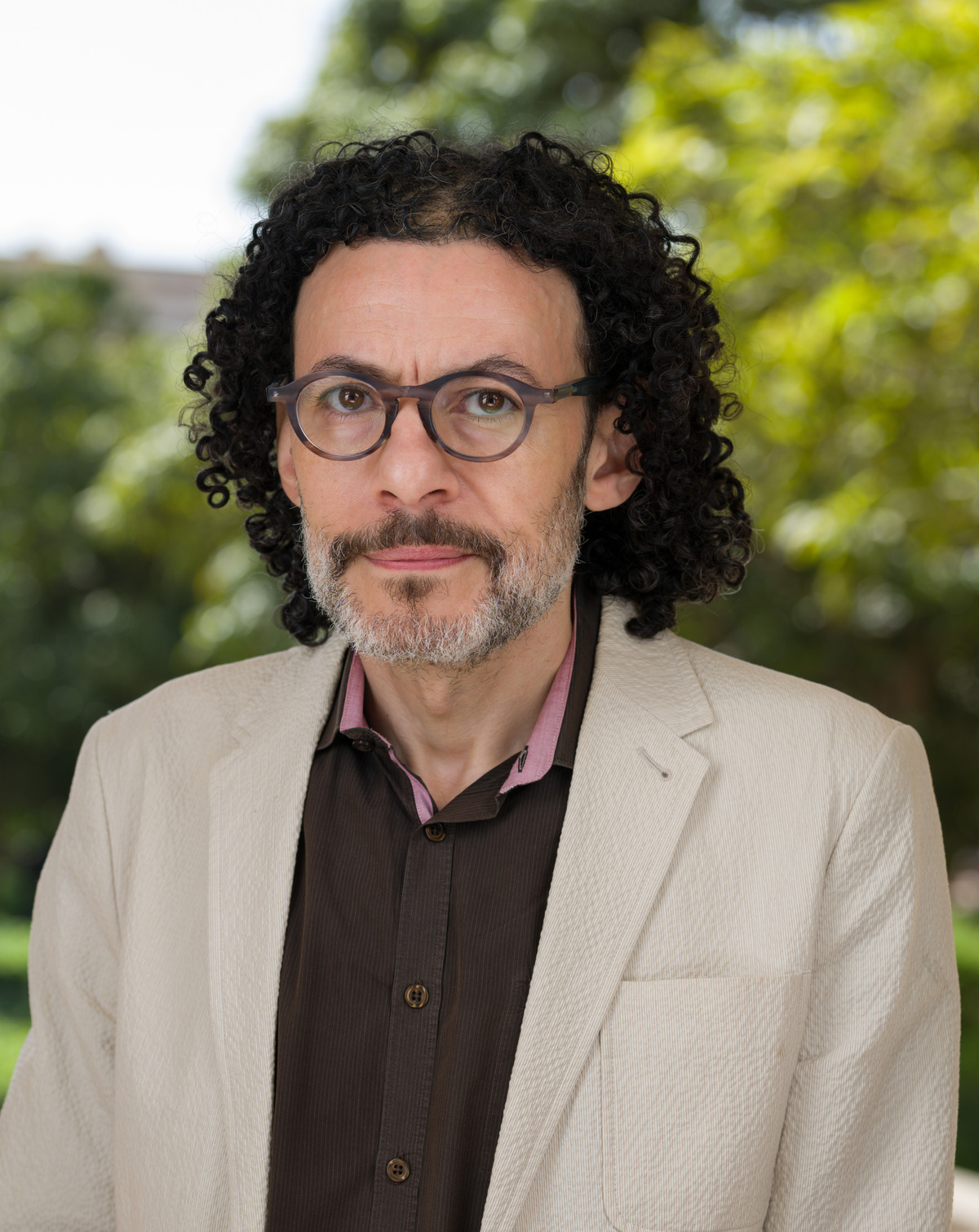 headshot of a man wearing glasses in an outdoor setting