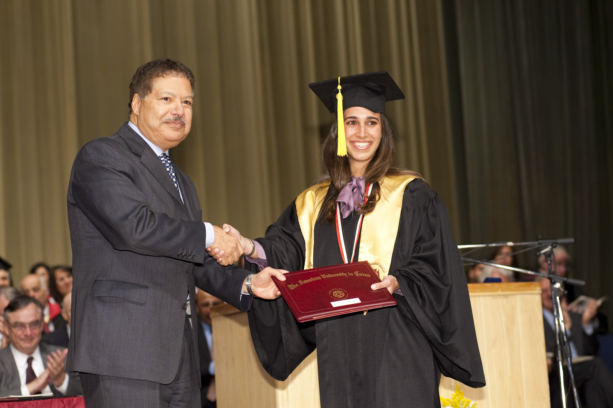 Dr. Ahmed Zewail giving a certificate to an AUC girl student wearing the cap and gown 