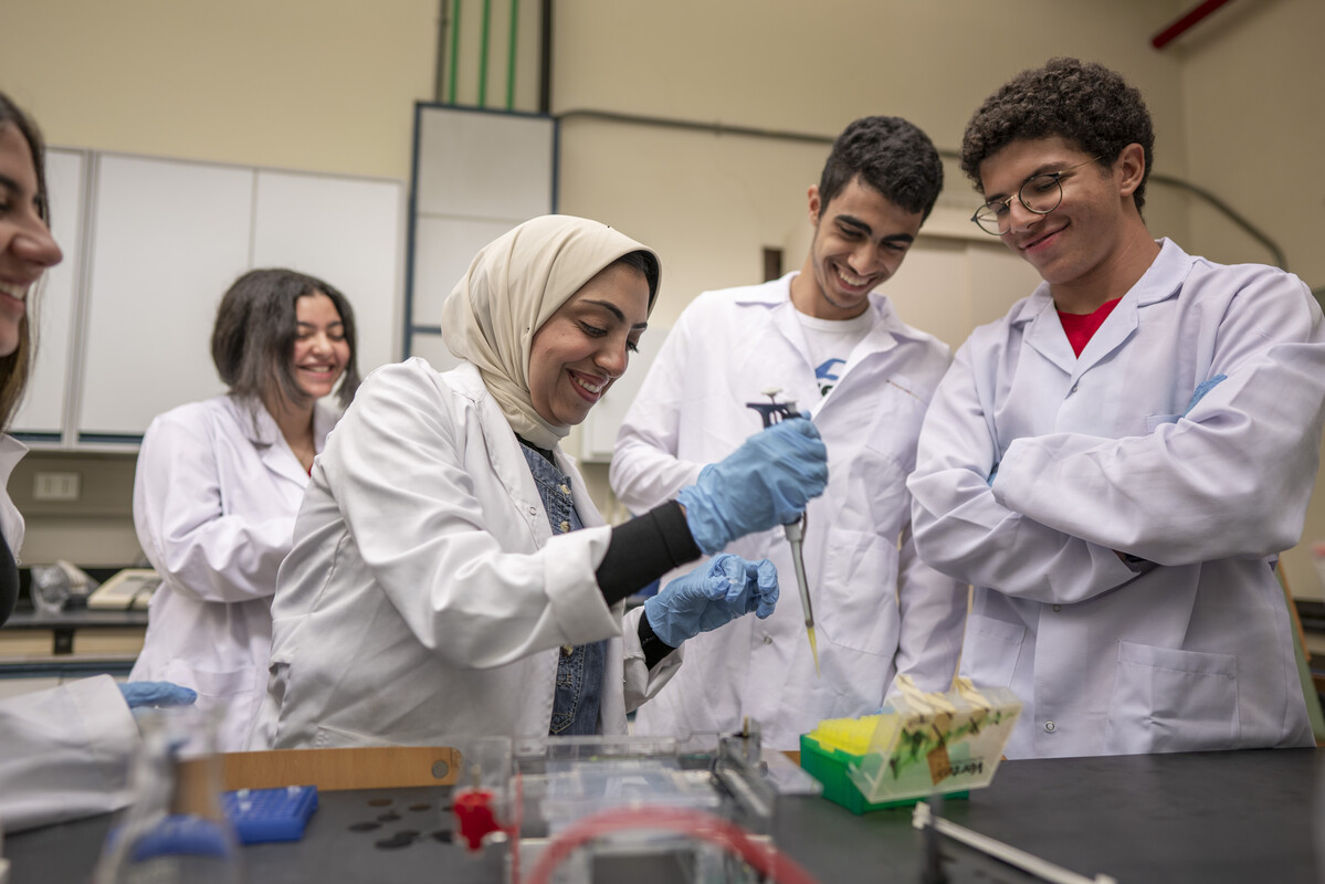 a group of students working in a lab with a professor carrying out an experiement