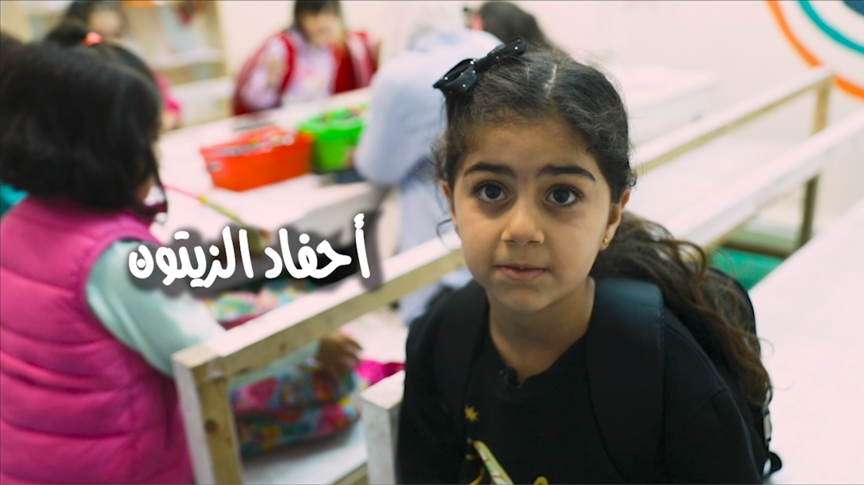 Title screen of "Descendants of Olive Trees" featuring small girls in a school setting 