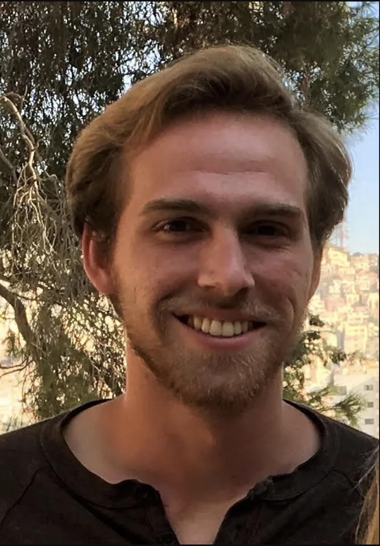 a man with brown hair and brown beard smiling