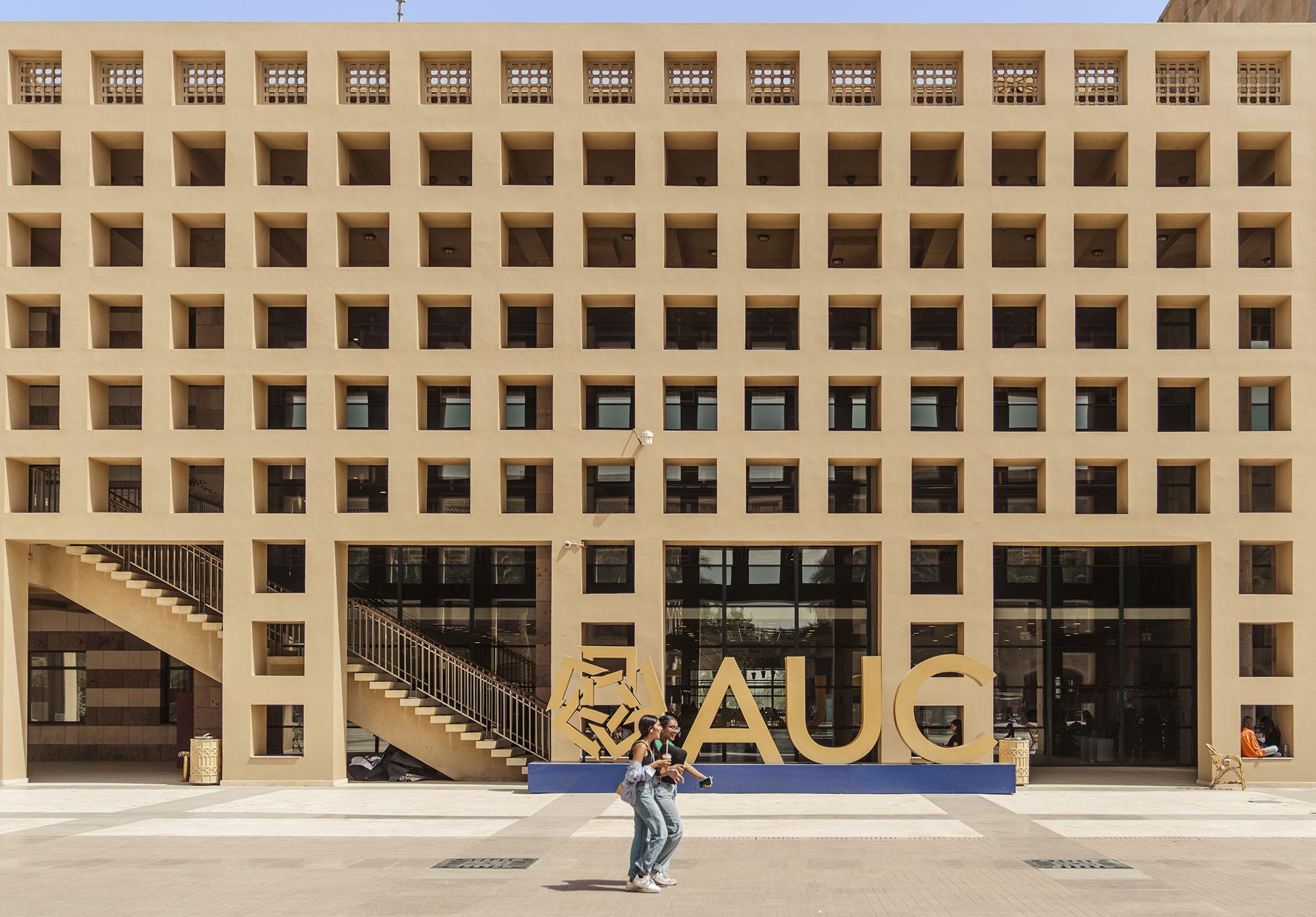 Beige building with hollow squares and a AUC sign in gold 