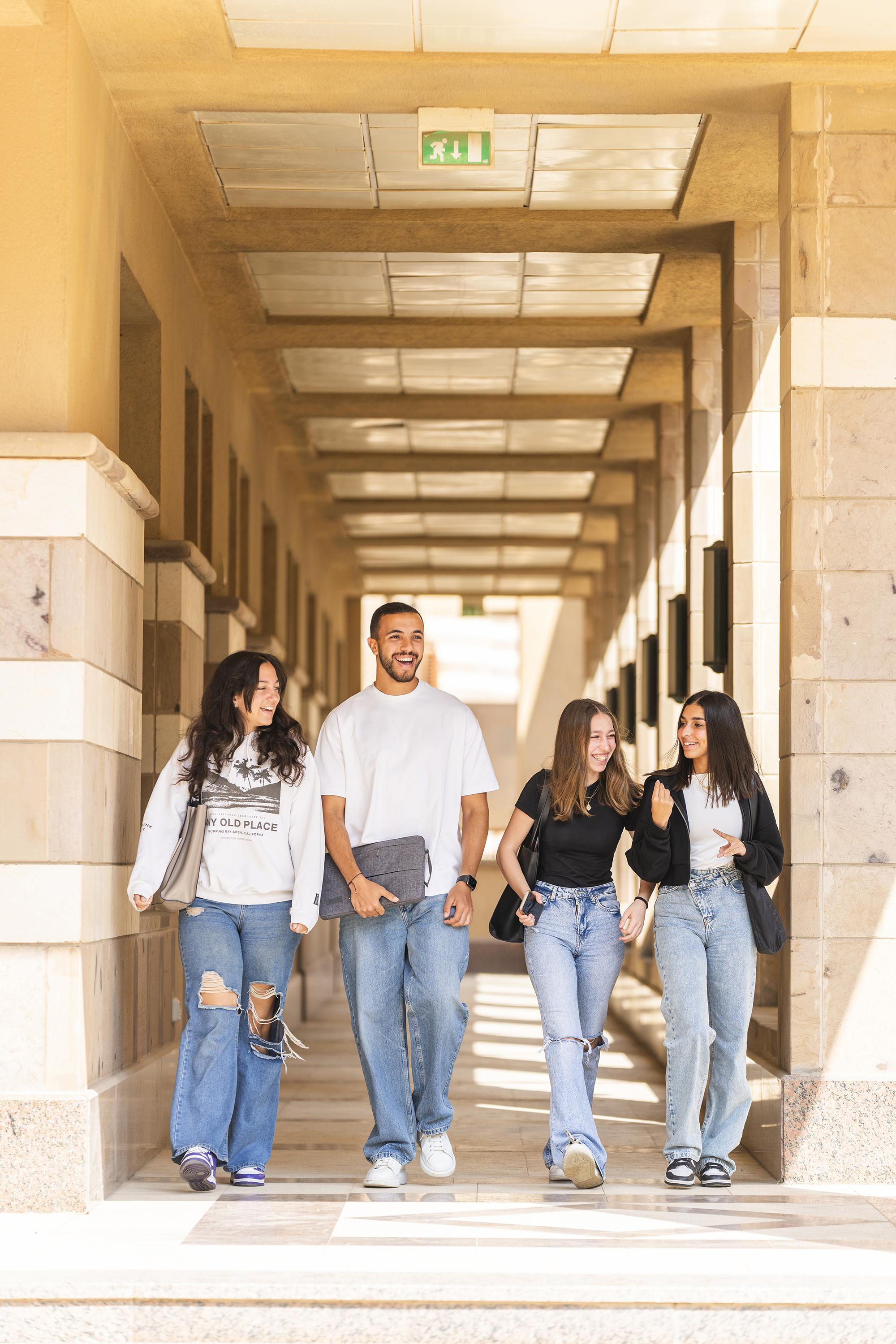 a group of boys and girls walking together on campus and smiling