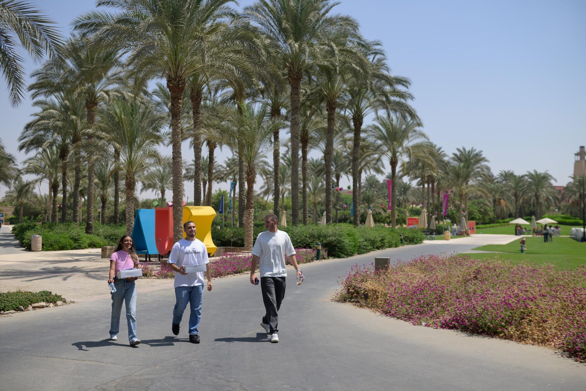 two boys and one girl walking on campus