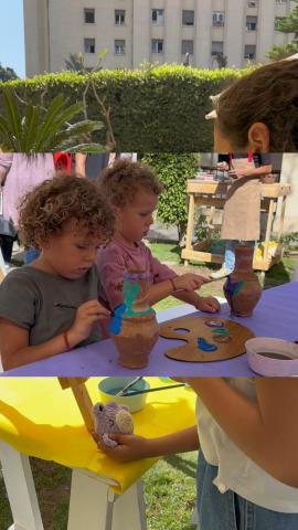 Young kids engaging in a fun pottery session, shaping clay pots together at a table.