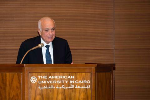 AUC Advisory Trustee Nabil Elaraby standing in front of an AUC podium speaking through a microphone