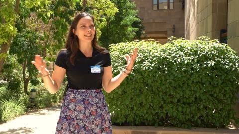 A girl is standing in a garden and is talking happily