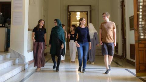 A group of international students from the CASA@AUC program are walking and smiling together in the historic palace at AUC Tahrir Square.