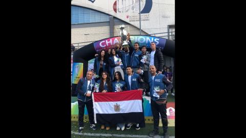 A group of athlete students holding the Egyptian flag