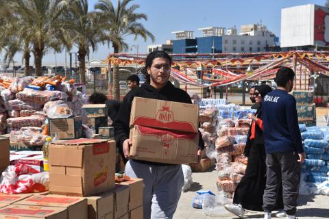 A student carries a box in the midst of piles of packaged food boxes