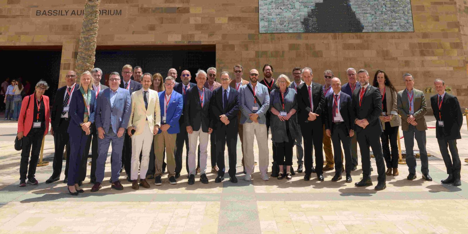 A group photo of visiting AAICU leaders standing in front of Bassily Auditorium at AUC New Cairo Campus