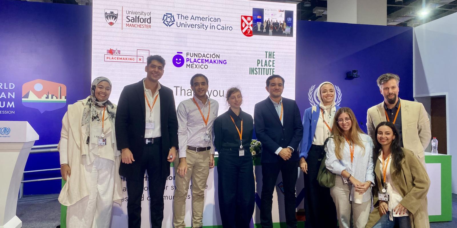 A group of men and women, including AUC architecture faculty and students, standing next to each other and smiling at the World Urban Forum