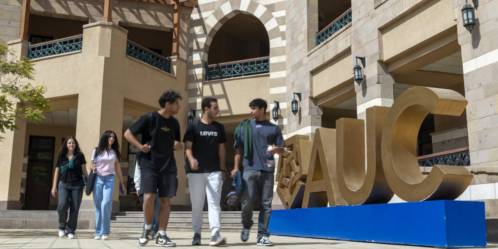 Students walking in front of a building at the New Cairo campus 