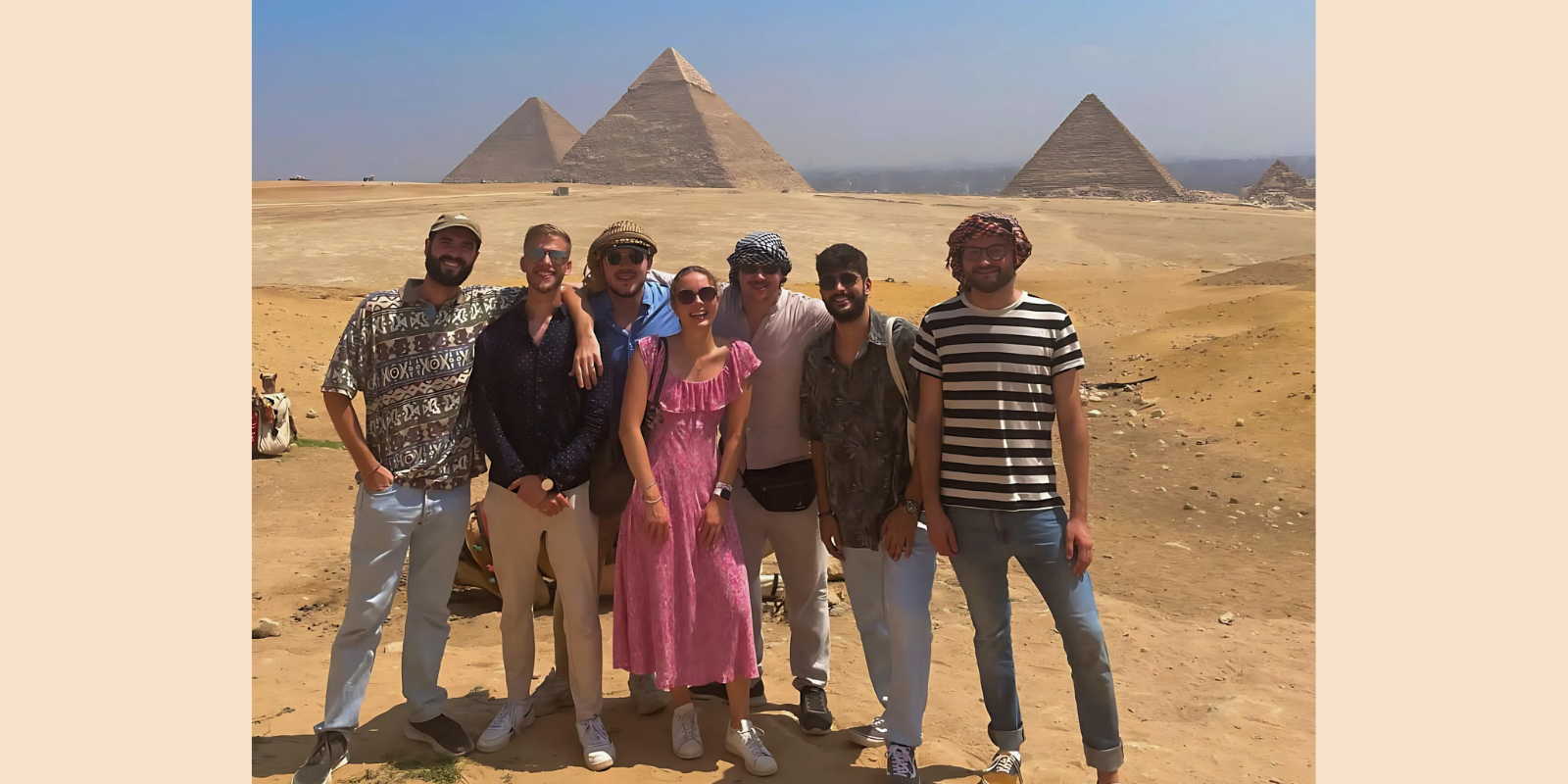 The CMEPS cohort (seven students) smiles in front of the Pyramids of Giza.