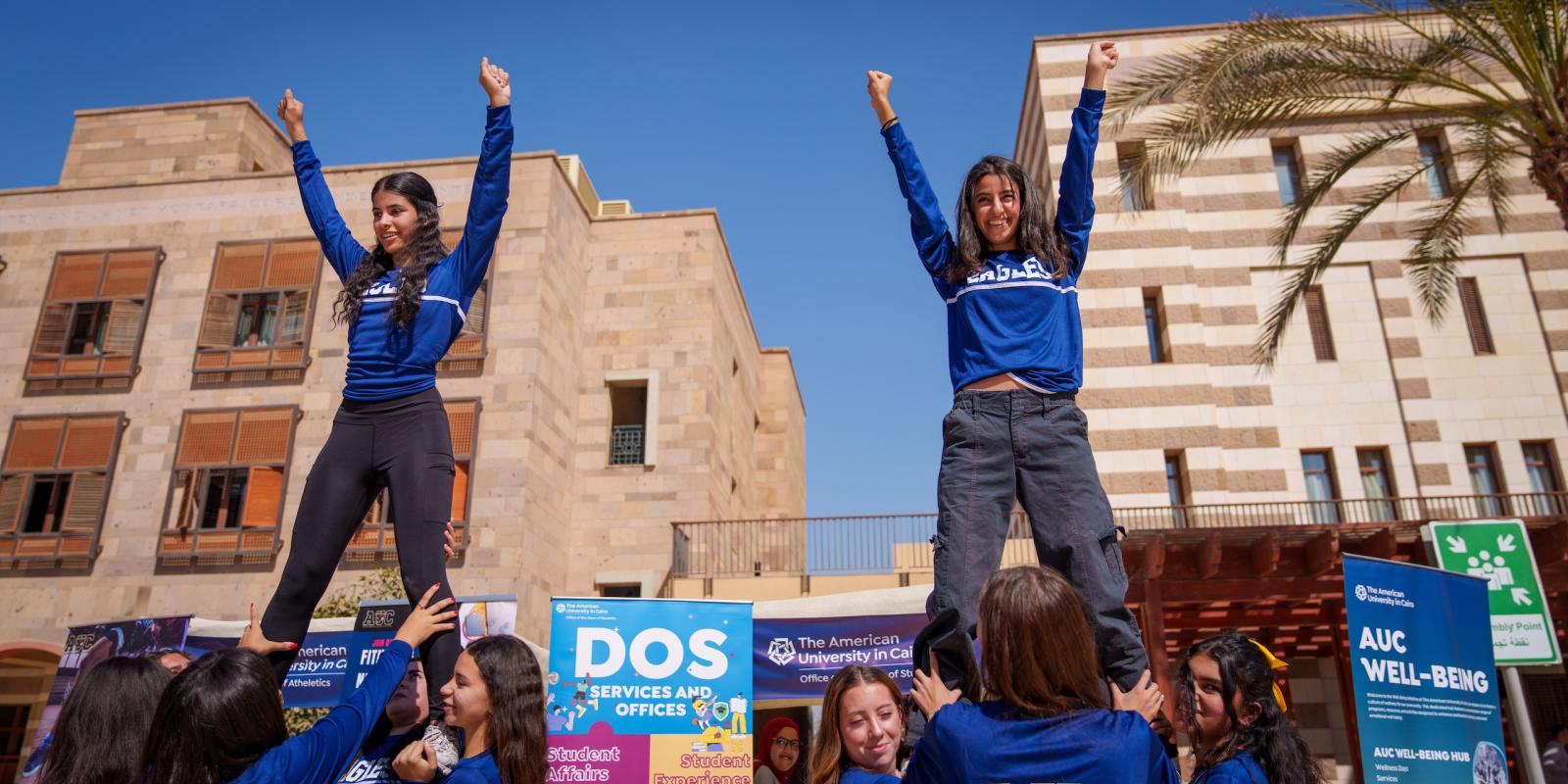 Two AUC girl students cheering in a student event 