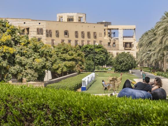 Students sitting in garden on bean bags with a garden in the background