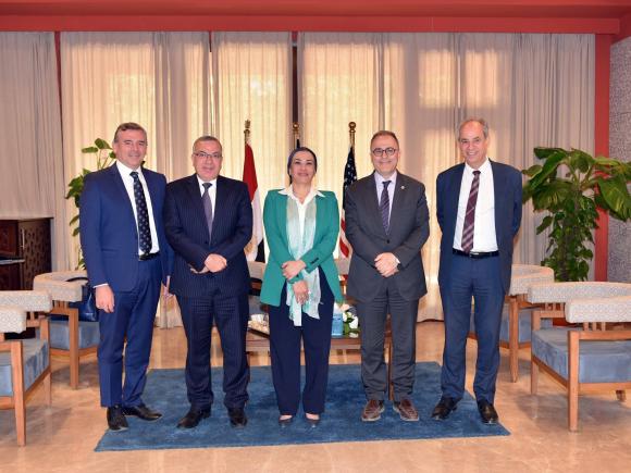 Four men and a woman standing together for a group photo