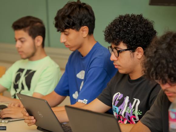 Boys in class working on their laptops