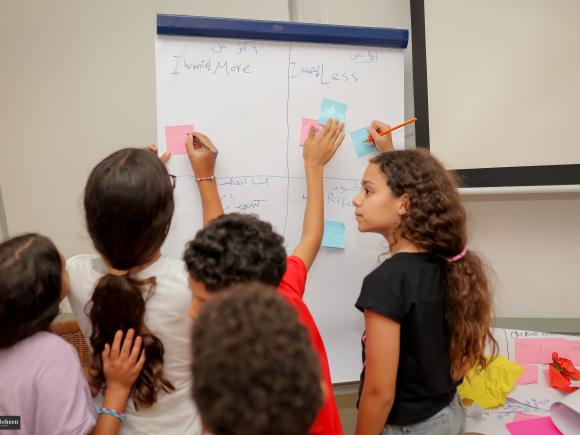 children in class writing on a flipboard