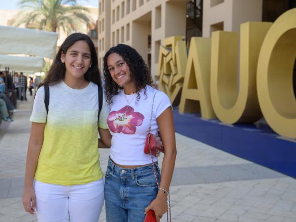 Two females standing beside the word AUC