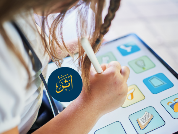 A girl is holding a tablet. Text: أثر