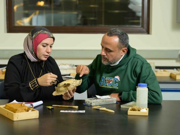  A woman and man holding a skull in a lab