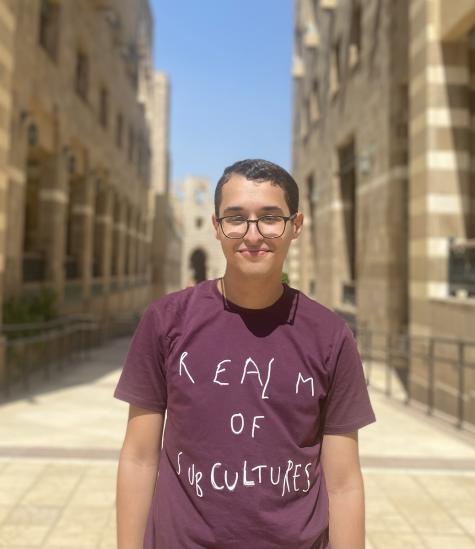 A male is wearing glasses and a t-shirt with the text: Realm of Sub Cultures