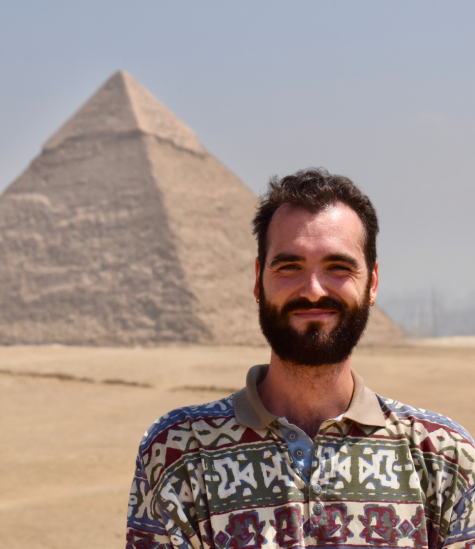 Isaac smiles for a headshot in front of the pyramids of Giza.