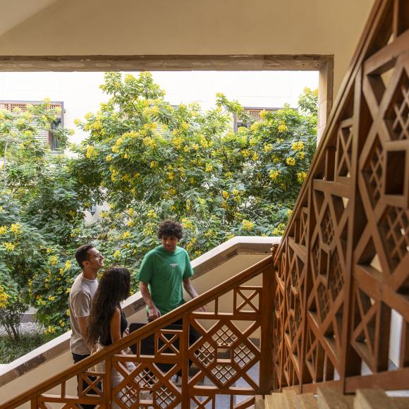 a group of students are walking up the stairs of a building at auc new cairo campus