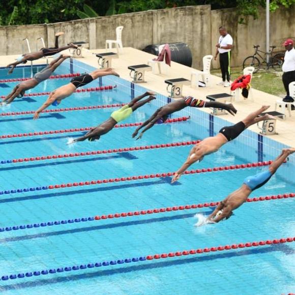 Swimmers jumping into the pool for a swimming competition