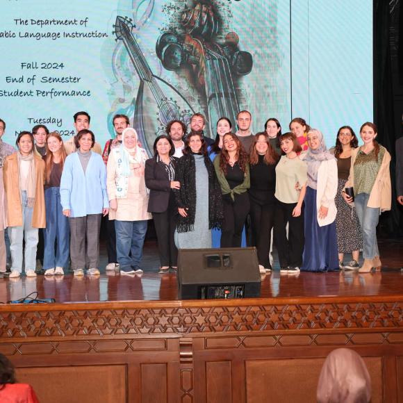 faculty and students on stage posing for group photo of 