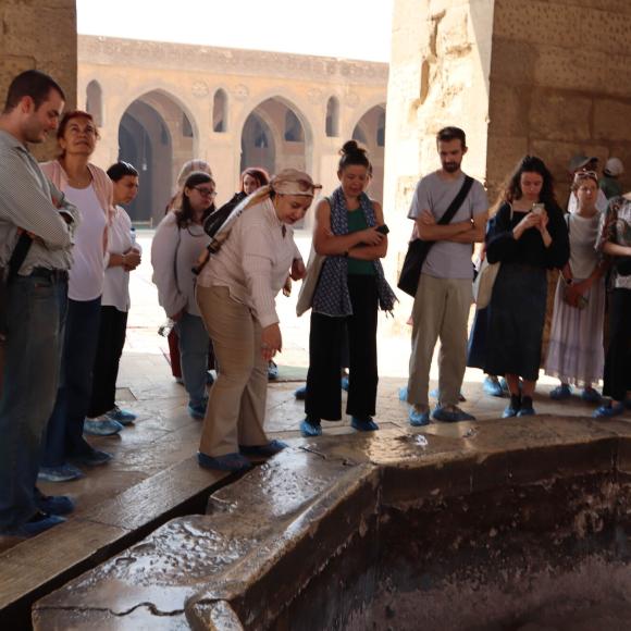 students on a field trip at an islamic heritage site and teacher explaining 