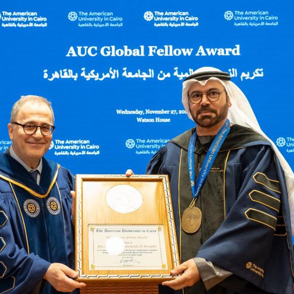 President Ahmad Dallal and Mohammad bin Abdullah Al Gergawi, Minister of Cabinet Affairs of the United Arab Emirates. They are holding a certificate. Text: AUC Global Fellow Award