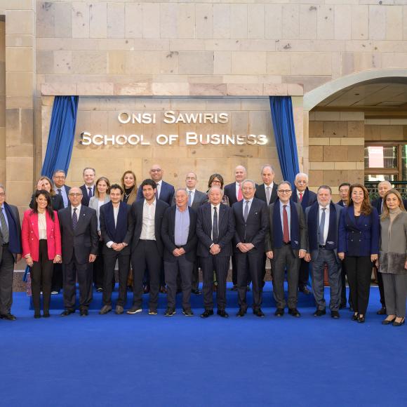 Senior l eaders from AUC, members of the Sawiris family and notable public figures standing together in front the of Onsi Sawiris School of Business at AUC