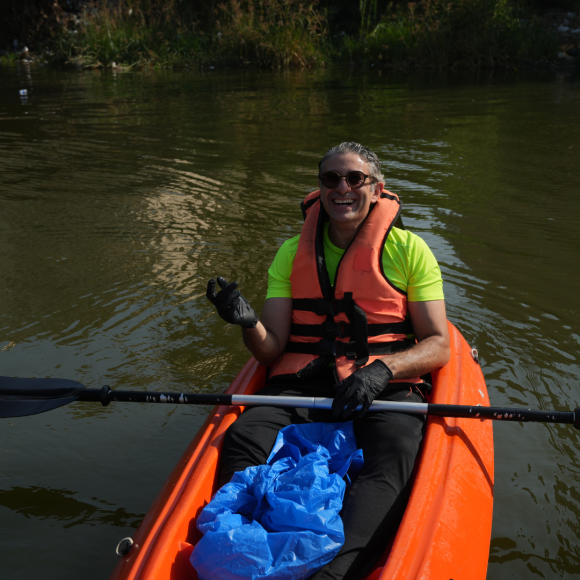 Assistant Professor Momen El-Husseiny on a boat in the Nile kayaking and picking up plastic waste from the Nile