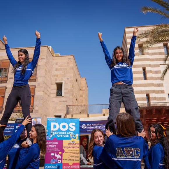 Two AUC girl students cheering in a student event 