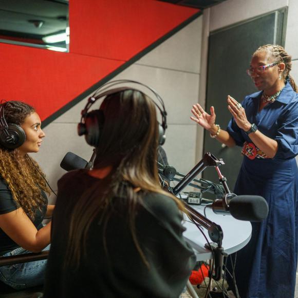 Two students with a professor in a studio