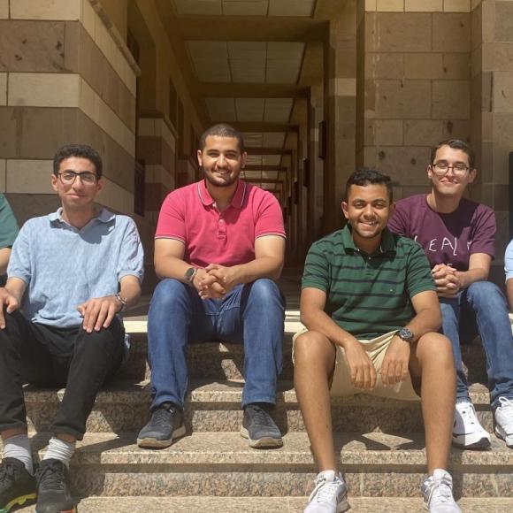 A group of students sitting on the stairs in the plaza