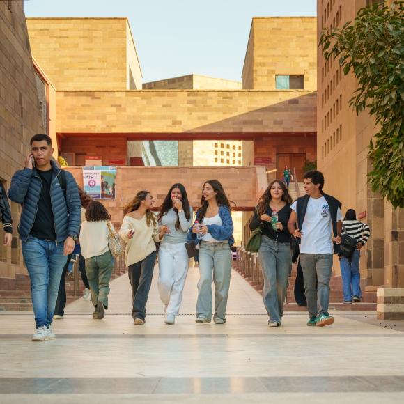 Male and female students walking in Plaza